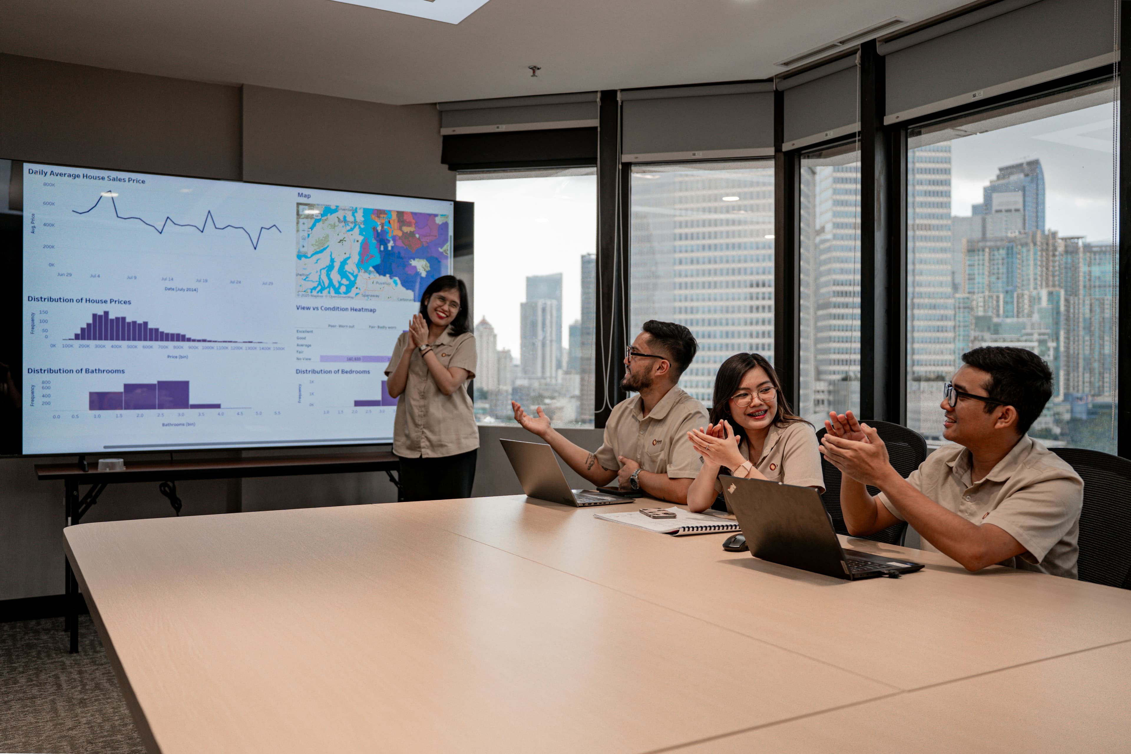 A team presenting project results in a meeting room, city skyline behind them